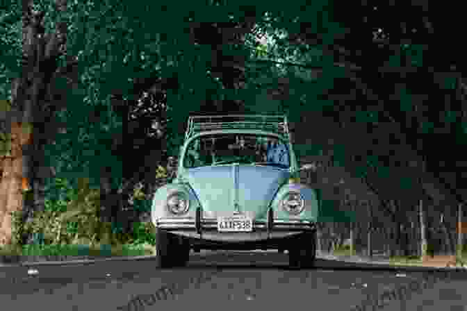 A Volkswagen Beetle Driving Down A Road Thinking Small: The Long Strange Trip Of The Volkswagen Beetle